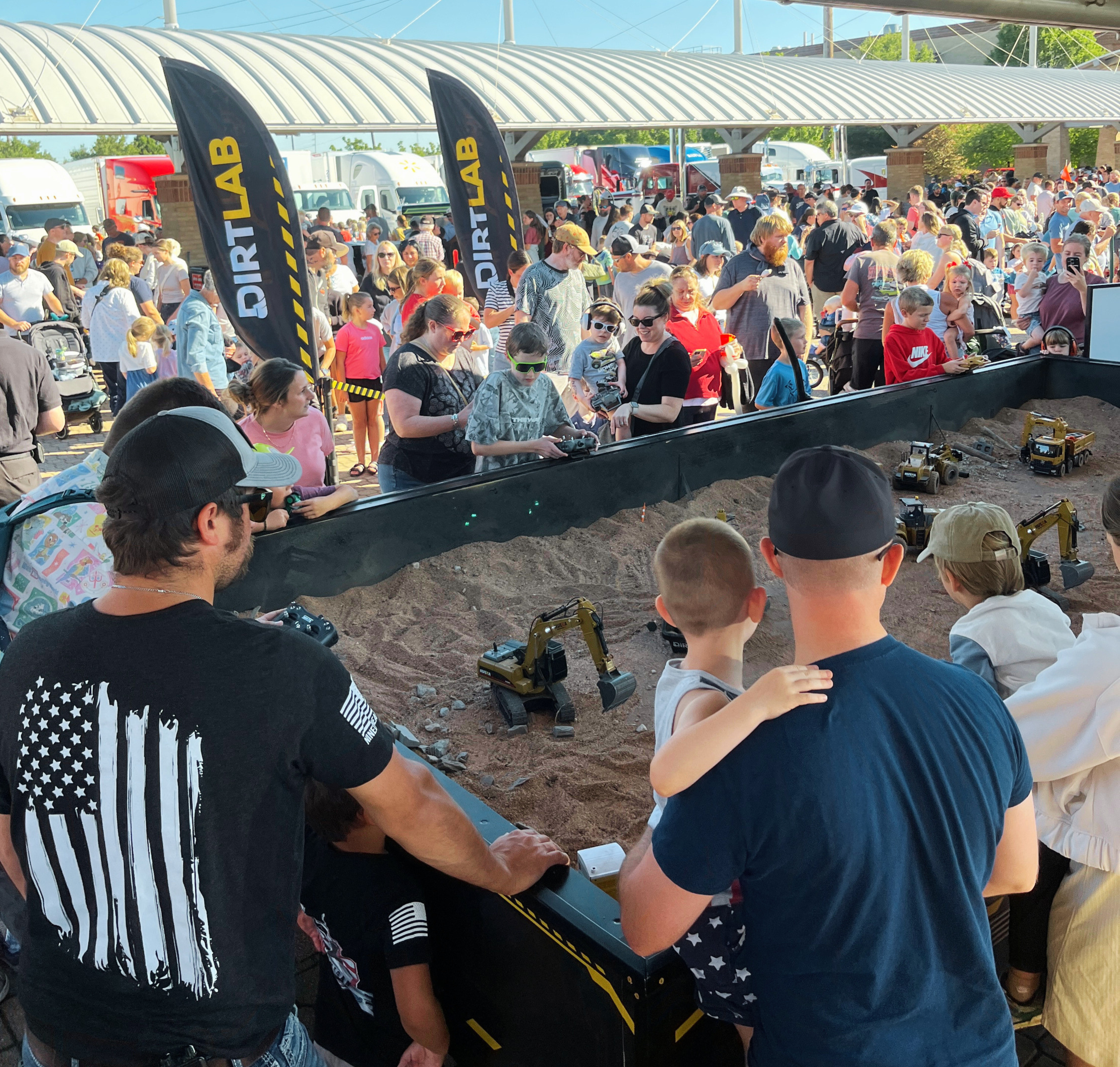 Crowd gathered around the DirtLab sandbox at an outdoor event