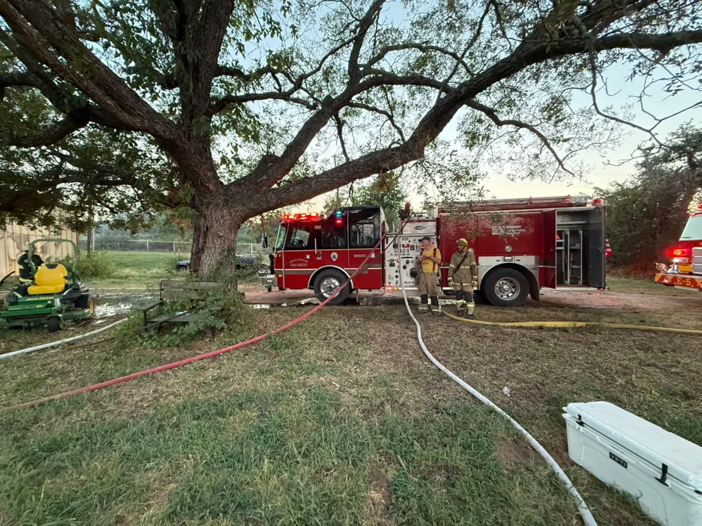 Firefighters beside a fire engine, with a cooler in the foreground