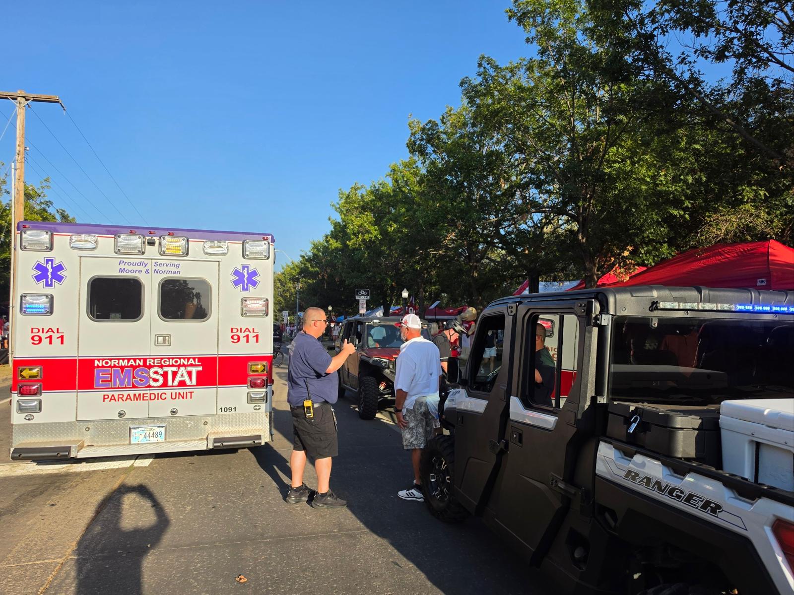 Event support personnel beside EMSSTAT and side-by-side vehicles carrying coolers