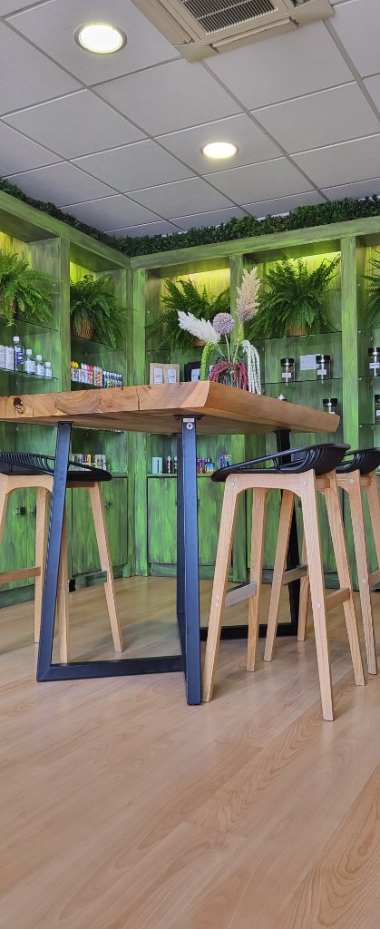 Table haute en bois massif avec tabourets, meubles verts en arrière-plan