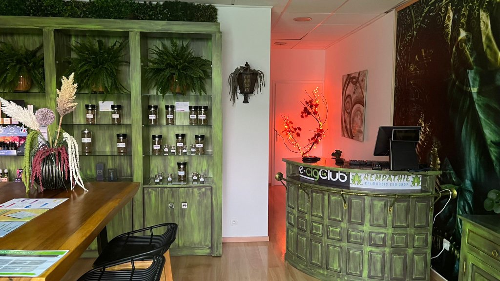 Comptoir peint vert avec enseigne e-cig Club et Hempathie, mur végétal