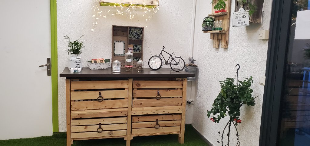 Meuble en caisses de bois avec vélo-horloge, plantes suspendues