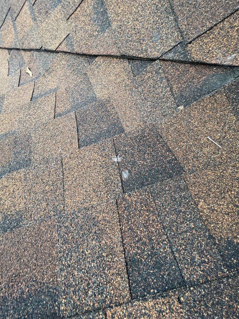 Hail damage roof shingles close up