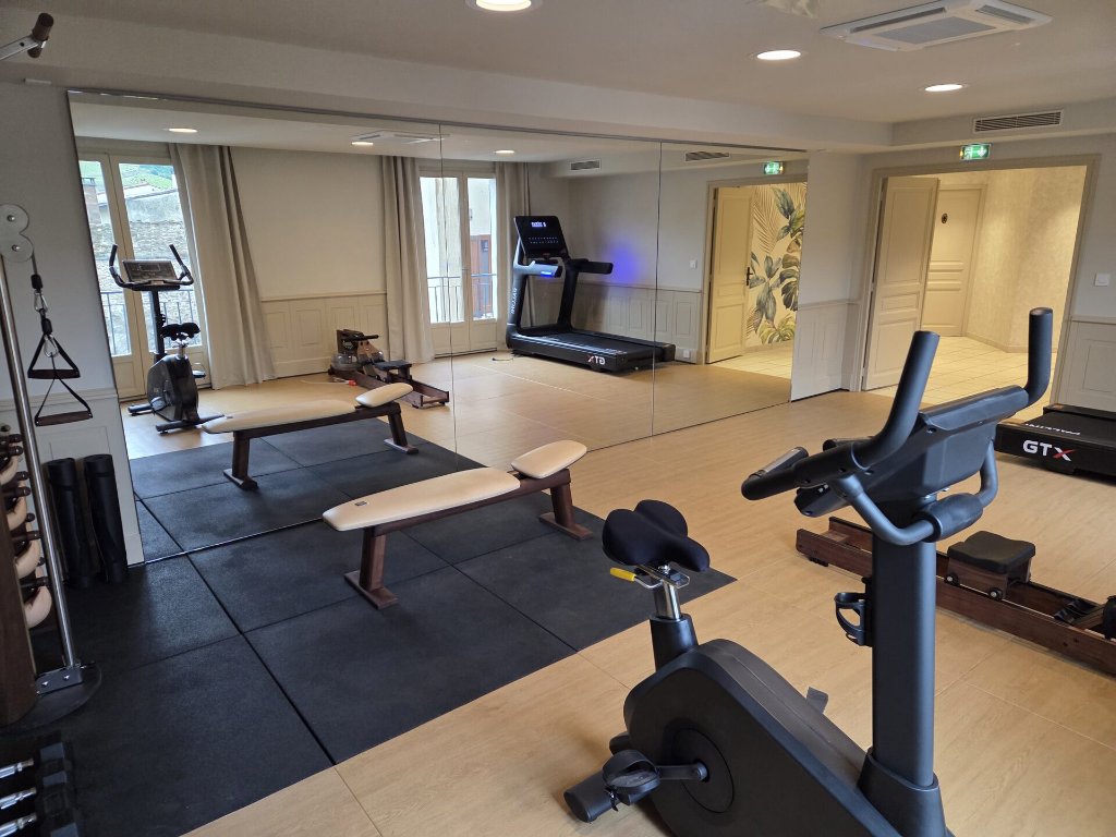 Salle de sport premium équipée par Perform Sport Room — vélos, tapis de course, miroir mural