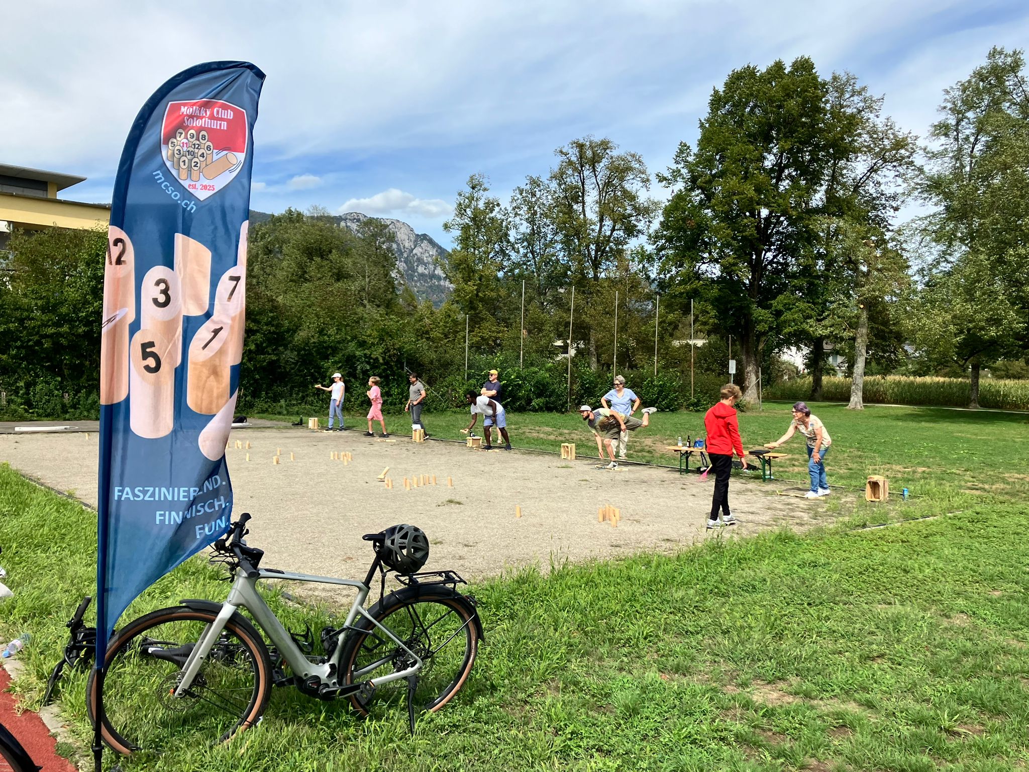 Mölkky-Spiel mit Clubfahne und Bergkulisse