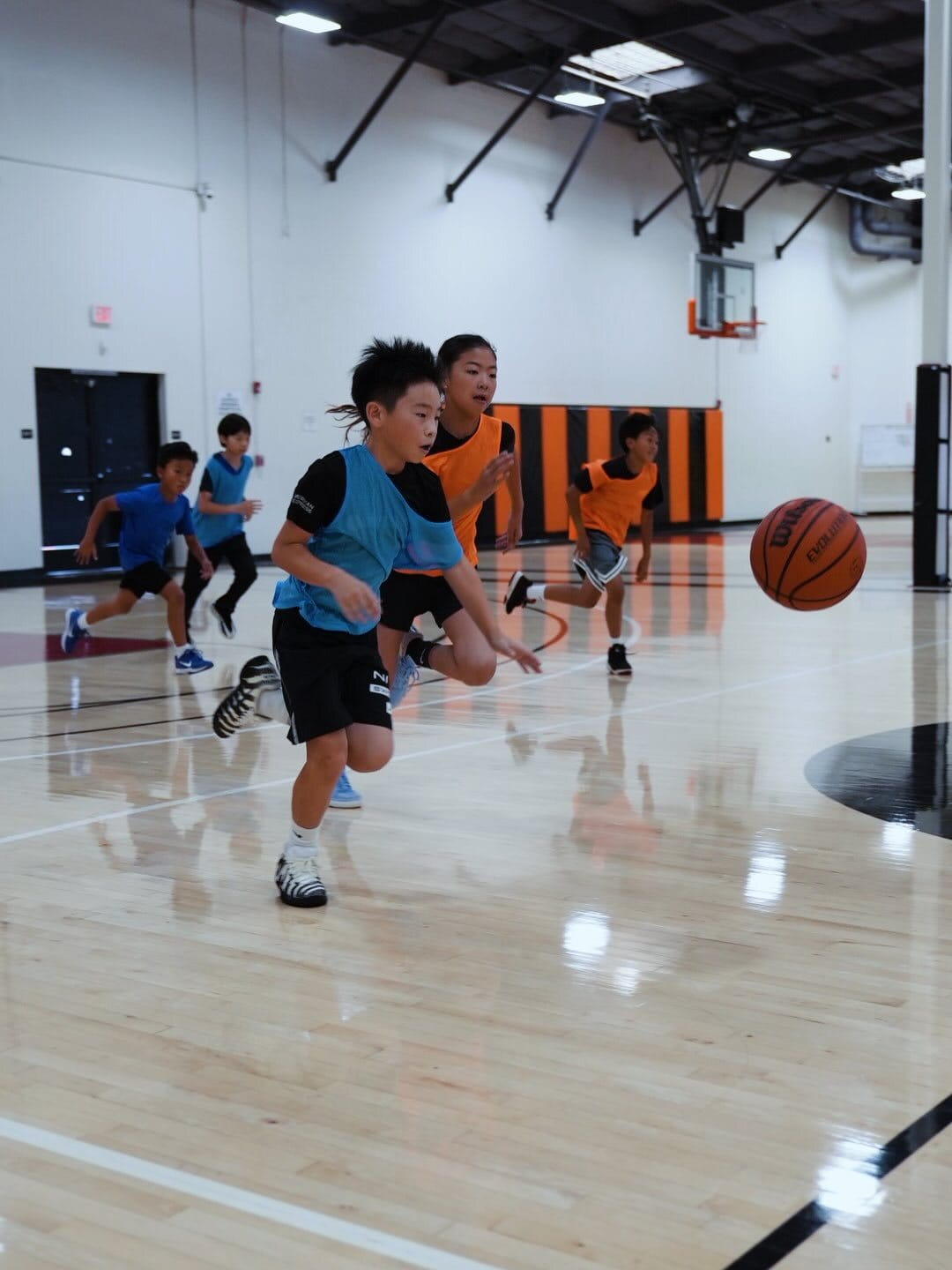 Youth basketball players scrimmaging on the Velocity HQ hardwood