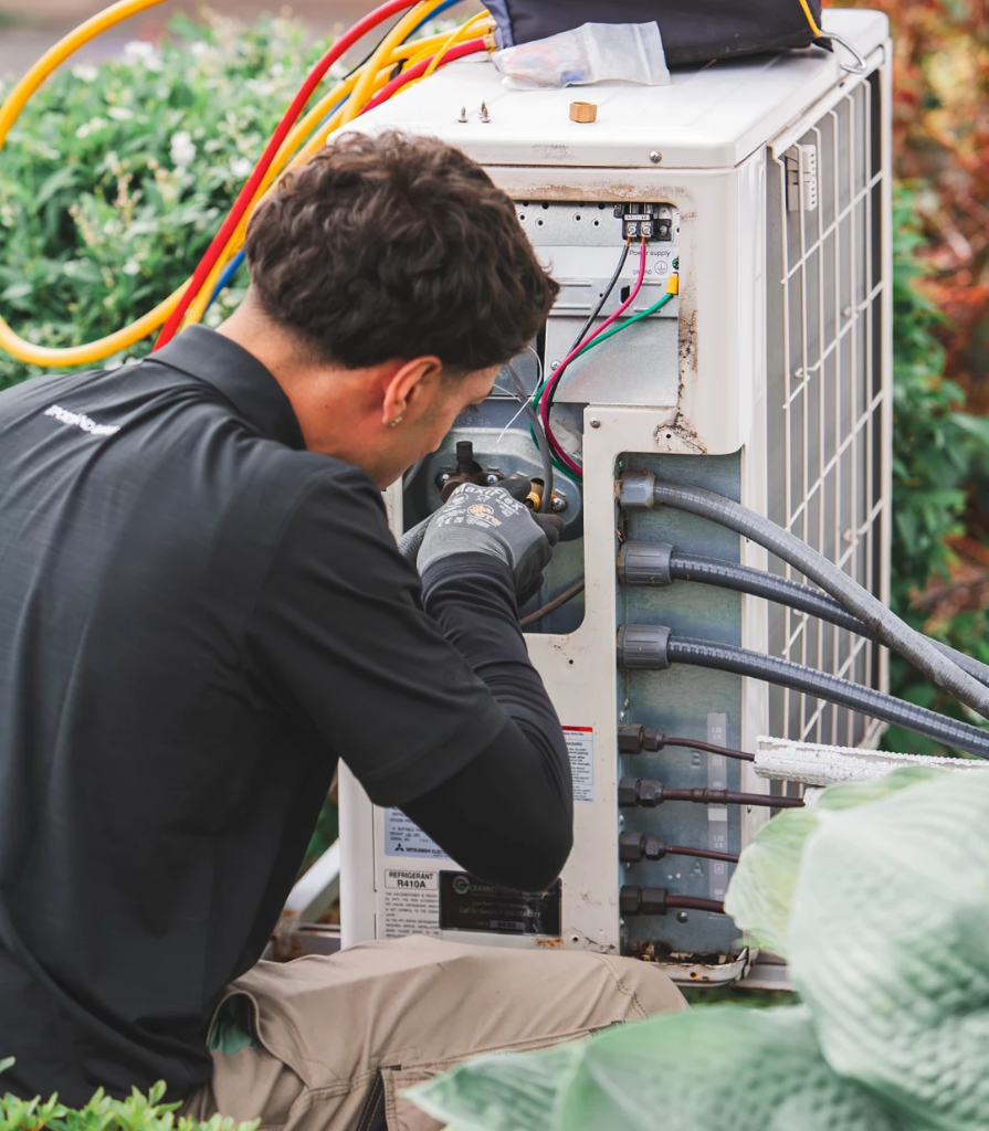 HVAC technician working on outdoor heat pump unit