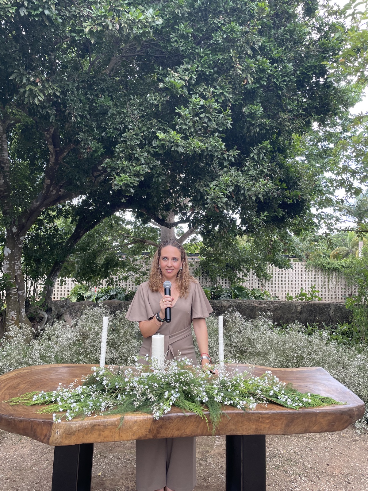Mujeres en una boda espiritual alrededor de un altar con flores y velas blancas