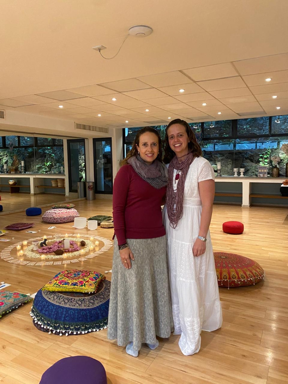 Mirelle y Michelle en el espacio ceremonial del círculo de cacao, rodeadas de velas y cojines