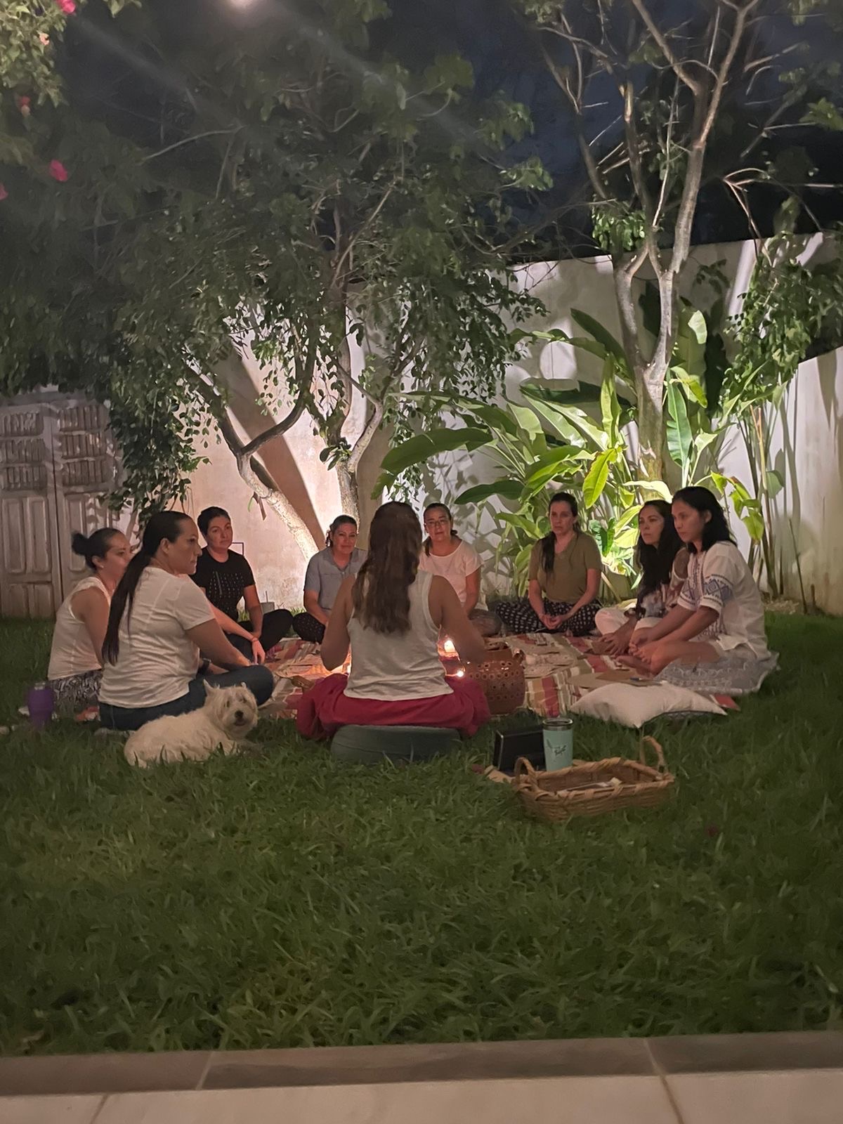 Círculo de cacao nocturno al aire libre en Mérida, mujeres sentadas en rueda con velas