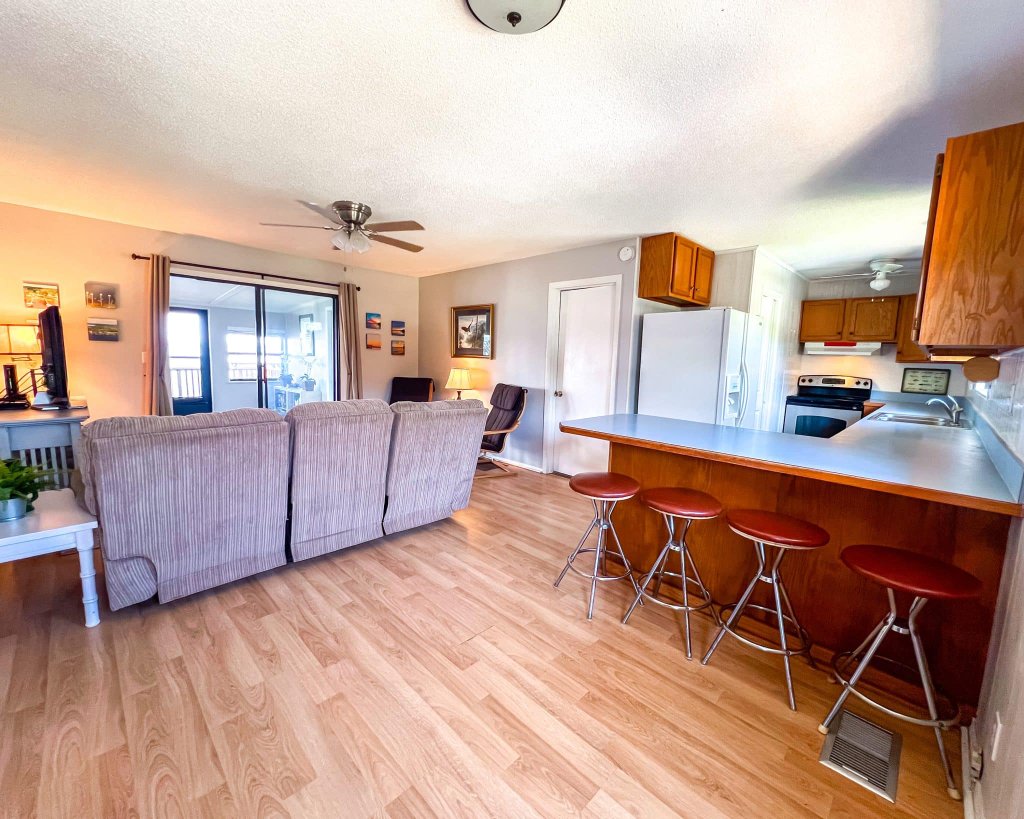 Open-plan living area with kitchen bar and deck access