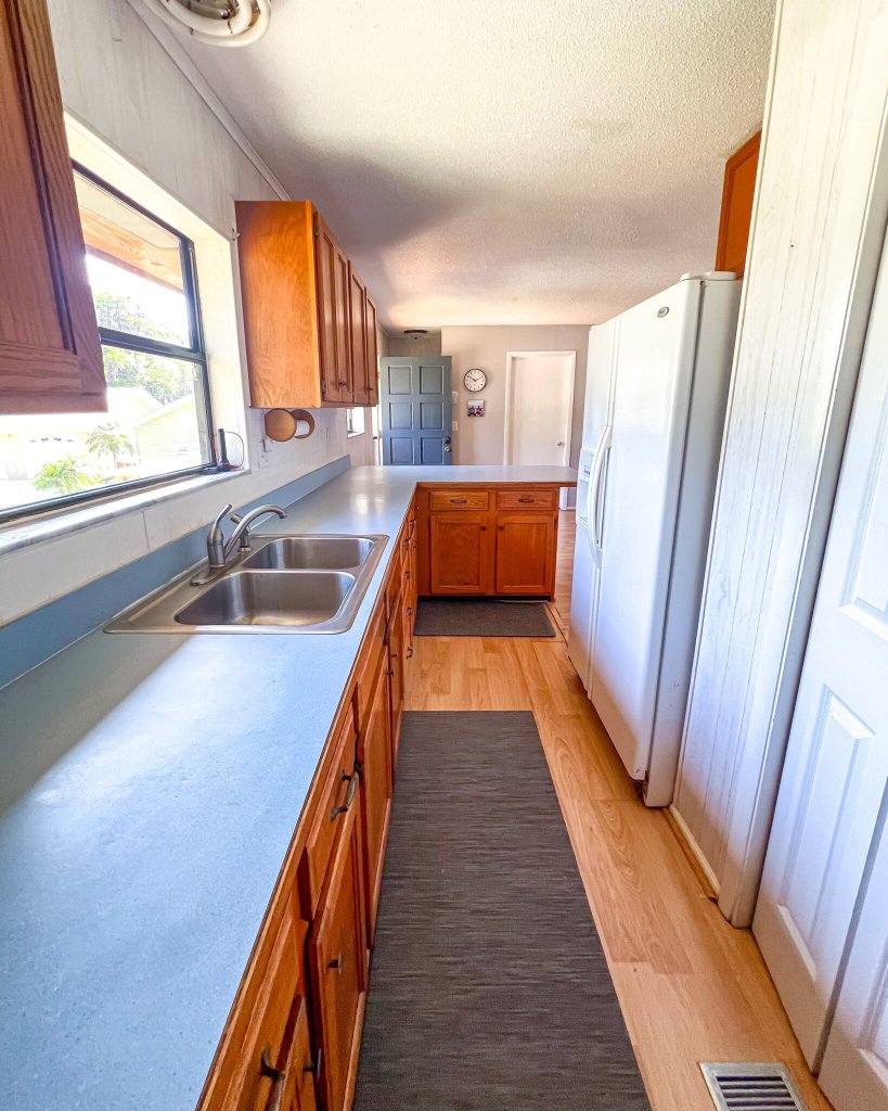 Galley kitchen with sink and pantry access