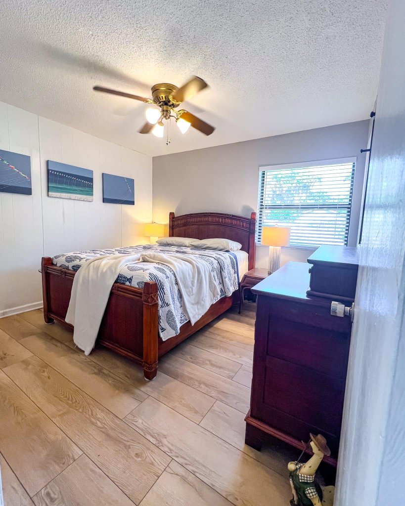 Dark wood bed frame with coastal artwork