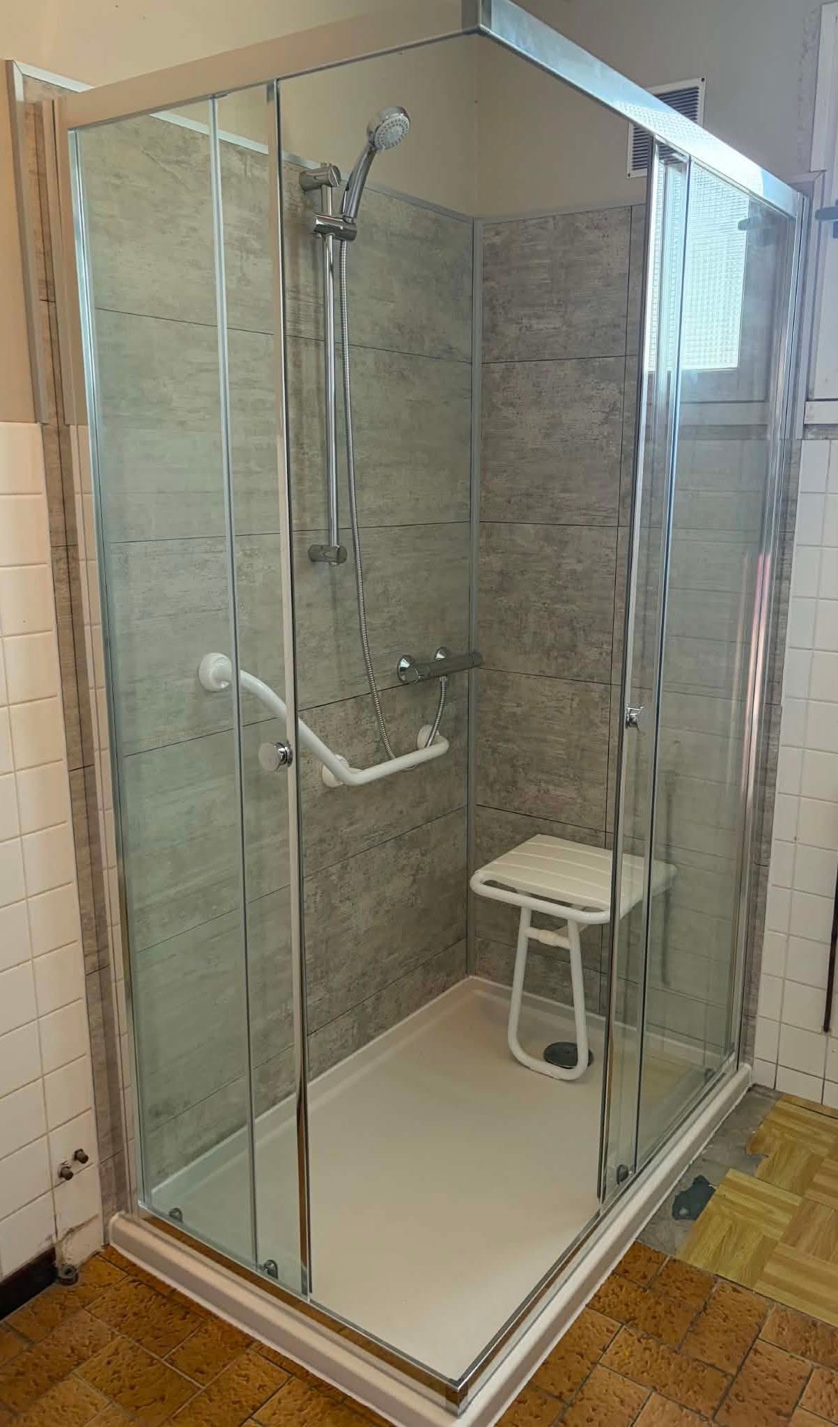 Cabine de douche accessible avec siège et barre d'appui