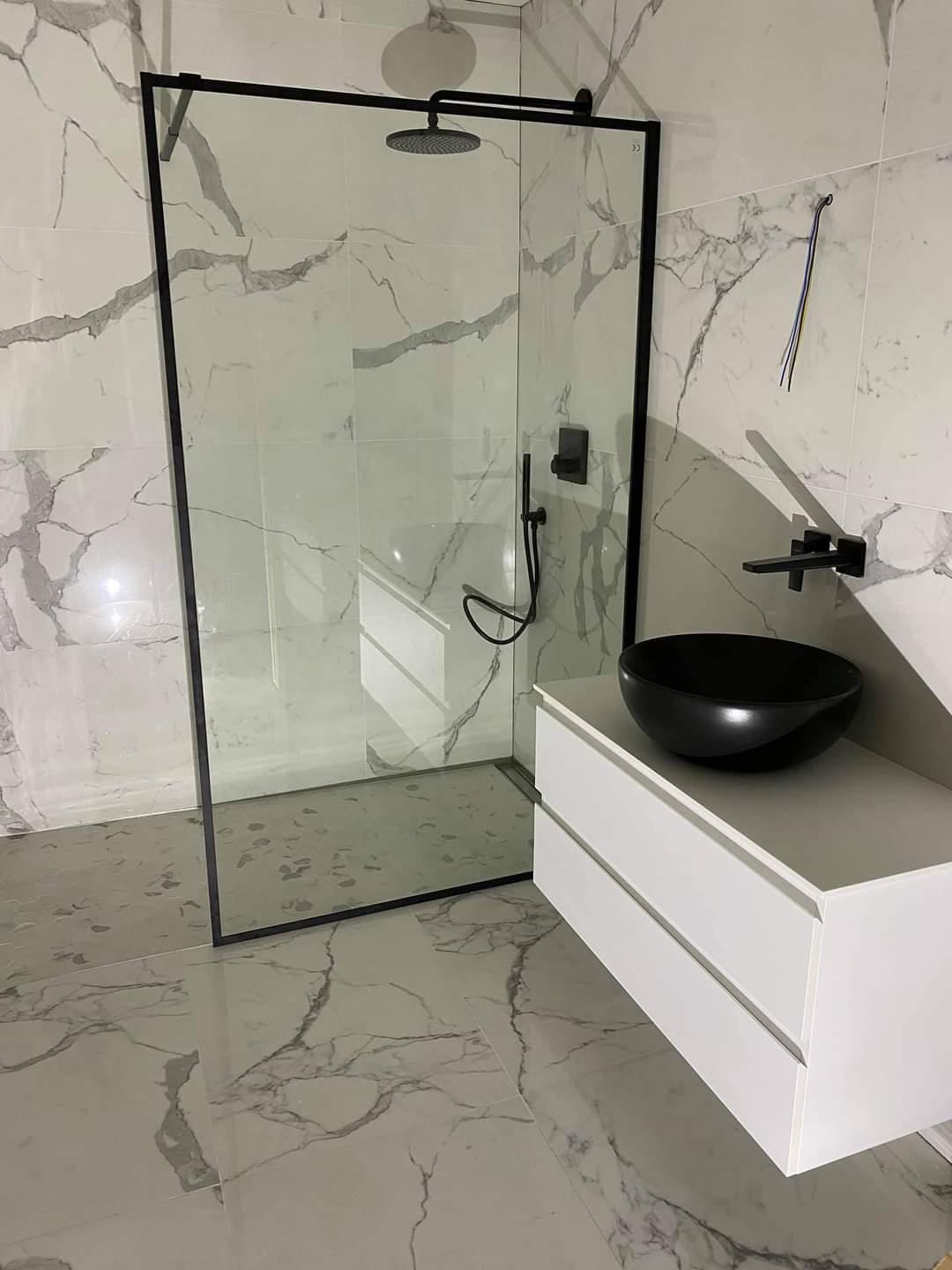 Douche italienne noire et meuble vasque sur sol marbré