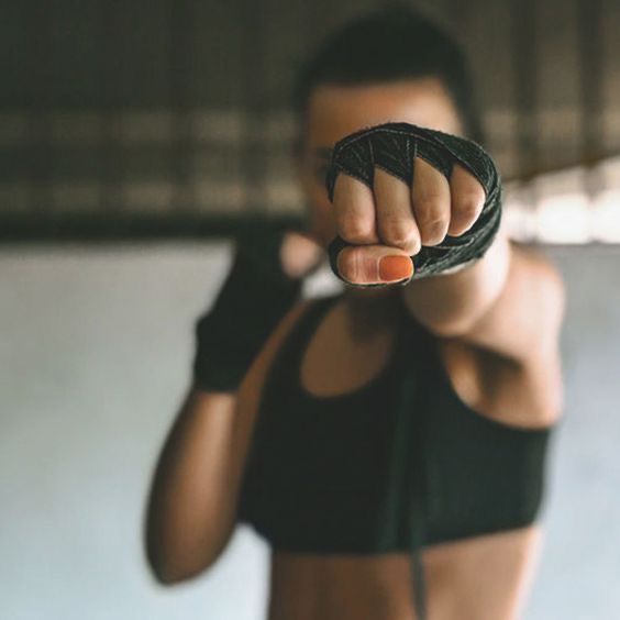 A woman throwing a punch with wrapped hands during a boxing session