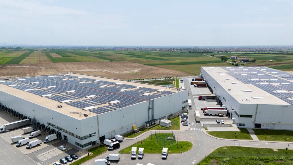 Aerial view of industrial logistics complex with solar panel roofs
