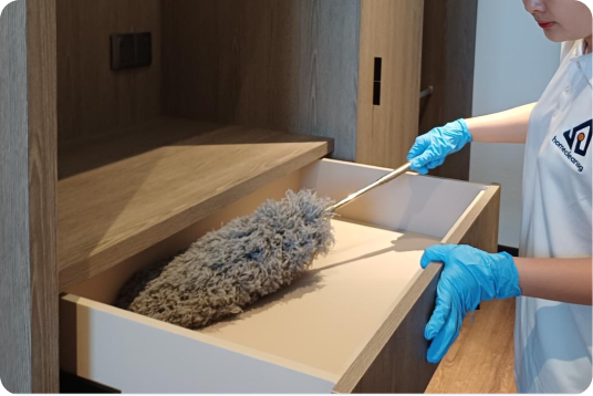 Dusting inside a wooden drawer