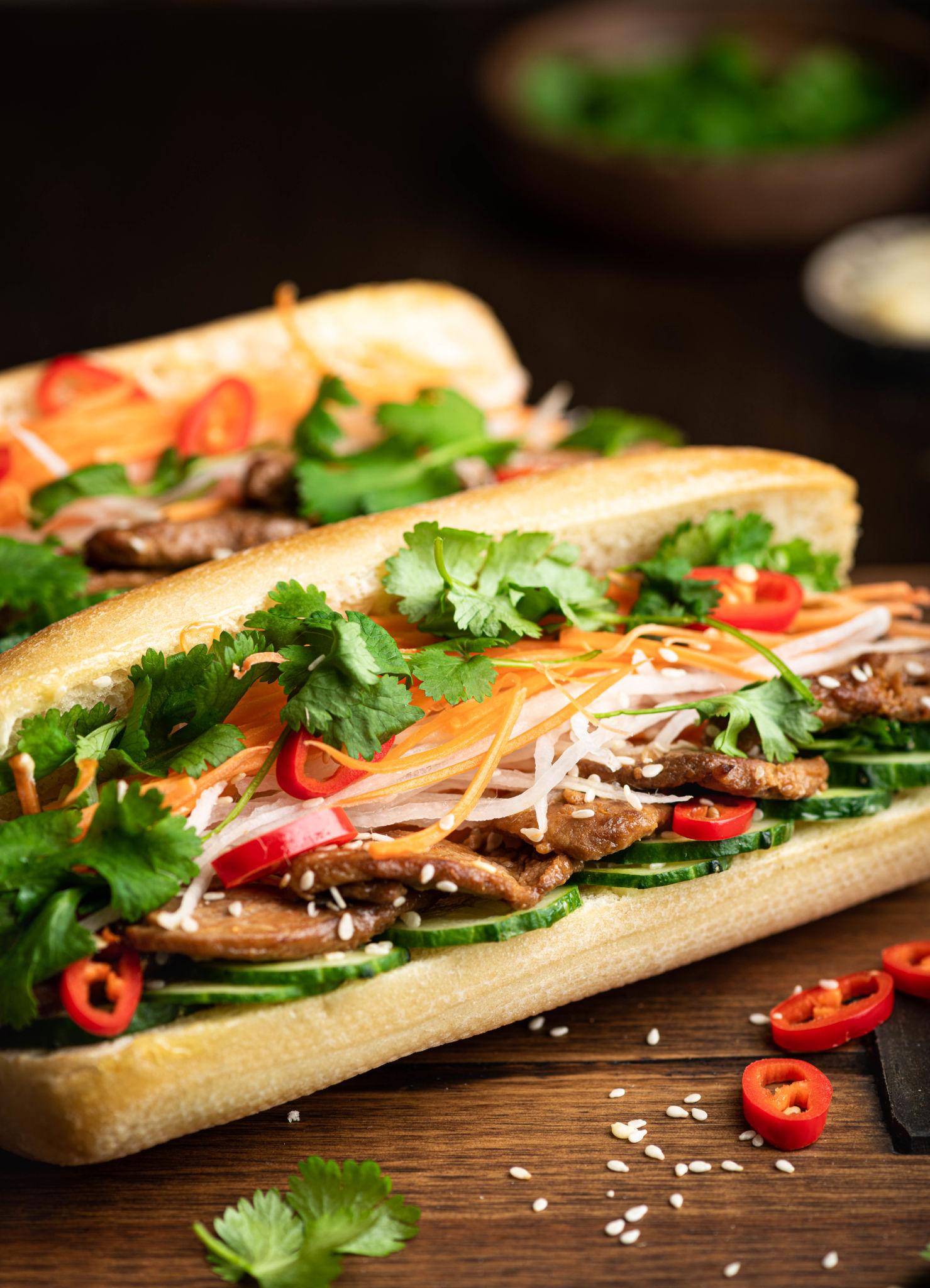 Bánh mì thịt nướng với đồ chua và rau thơm