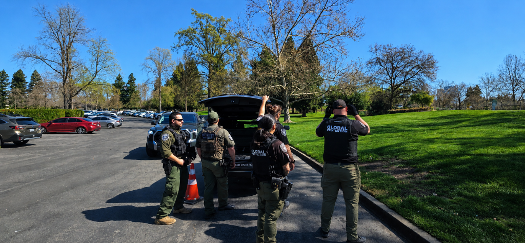 GPI Security officers coordinating with tactical personnel in an open field during daytime operations in Sacramento