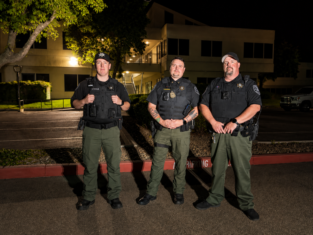 Request security coverage in Sacramento | GPI Security Three GPI armed security officers standing post at night outside commercial building in Sacramento