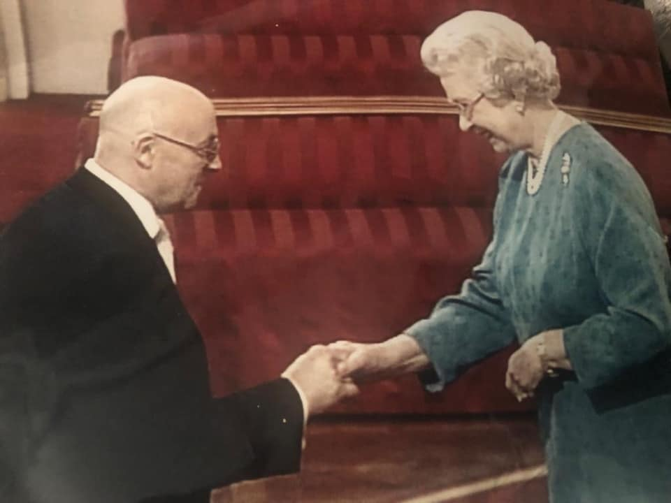 Michael receiving his MBE from Her Majesty The Queen
