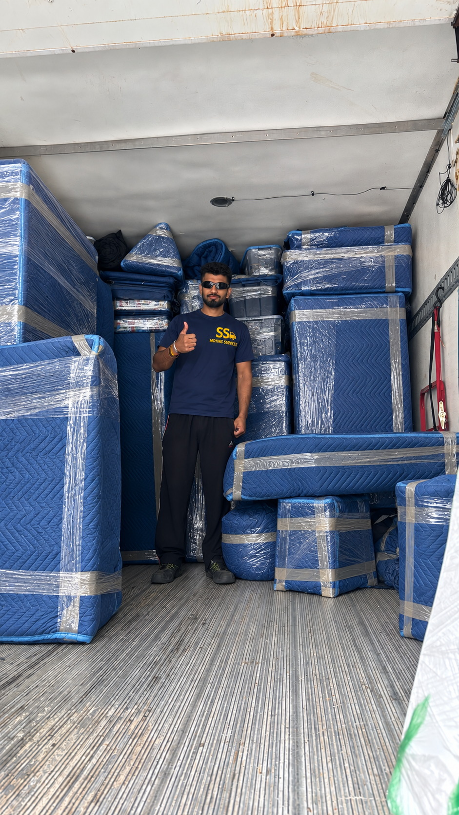 Mover inside the truck — every piece blanket-wrapped and strapped in