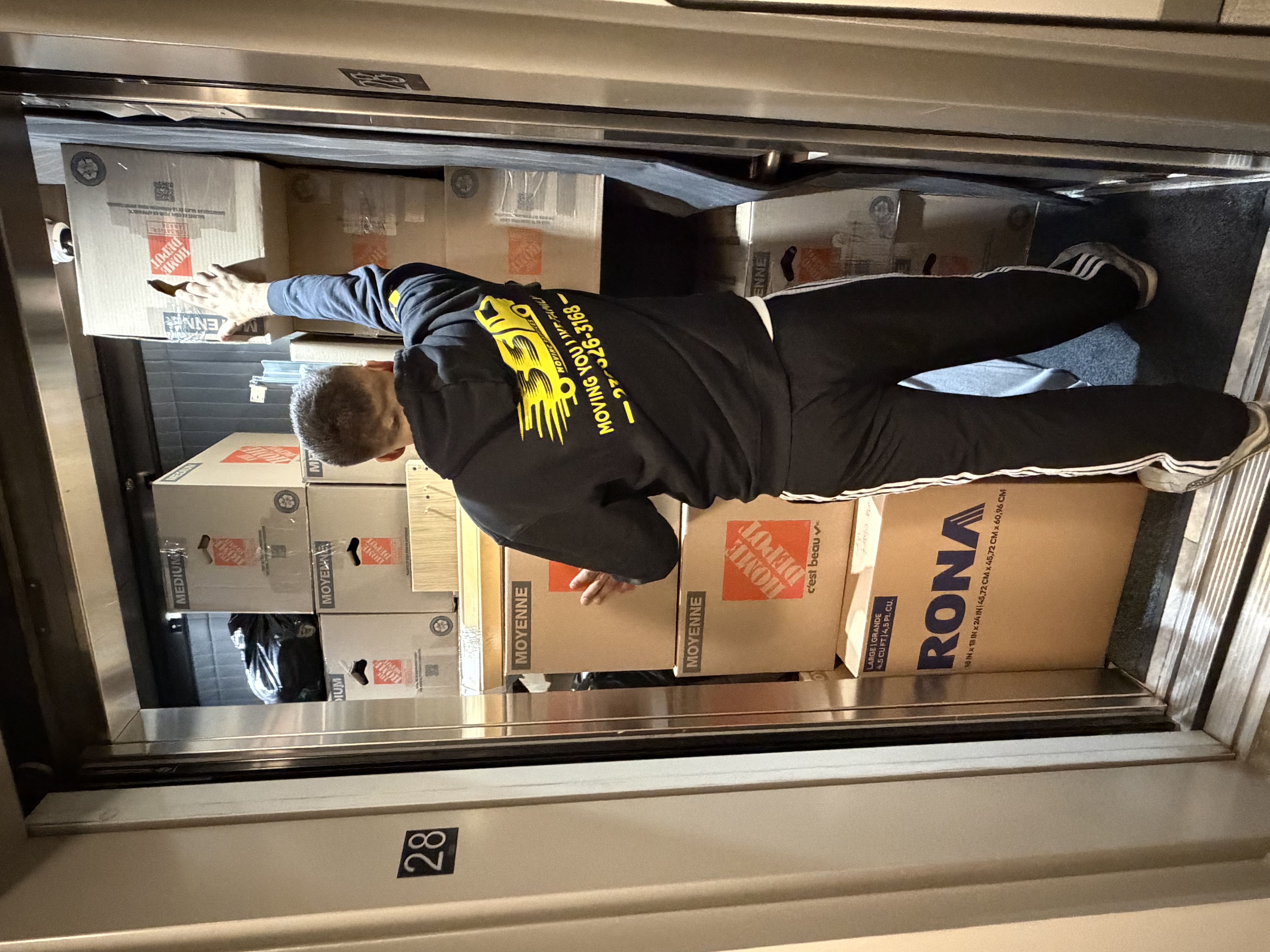Moving up to the 28th floor — elevator loaded with boxes