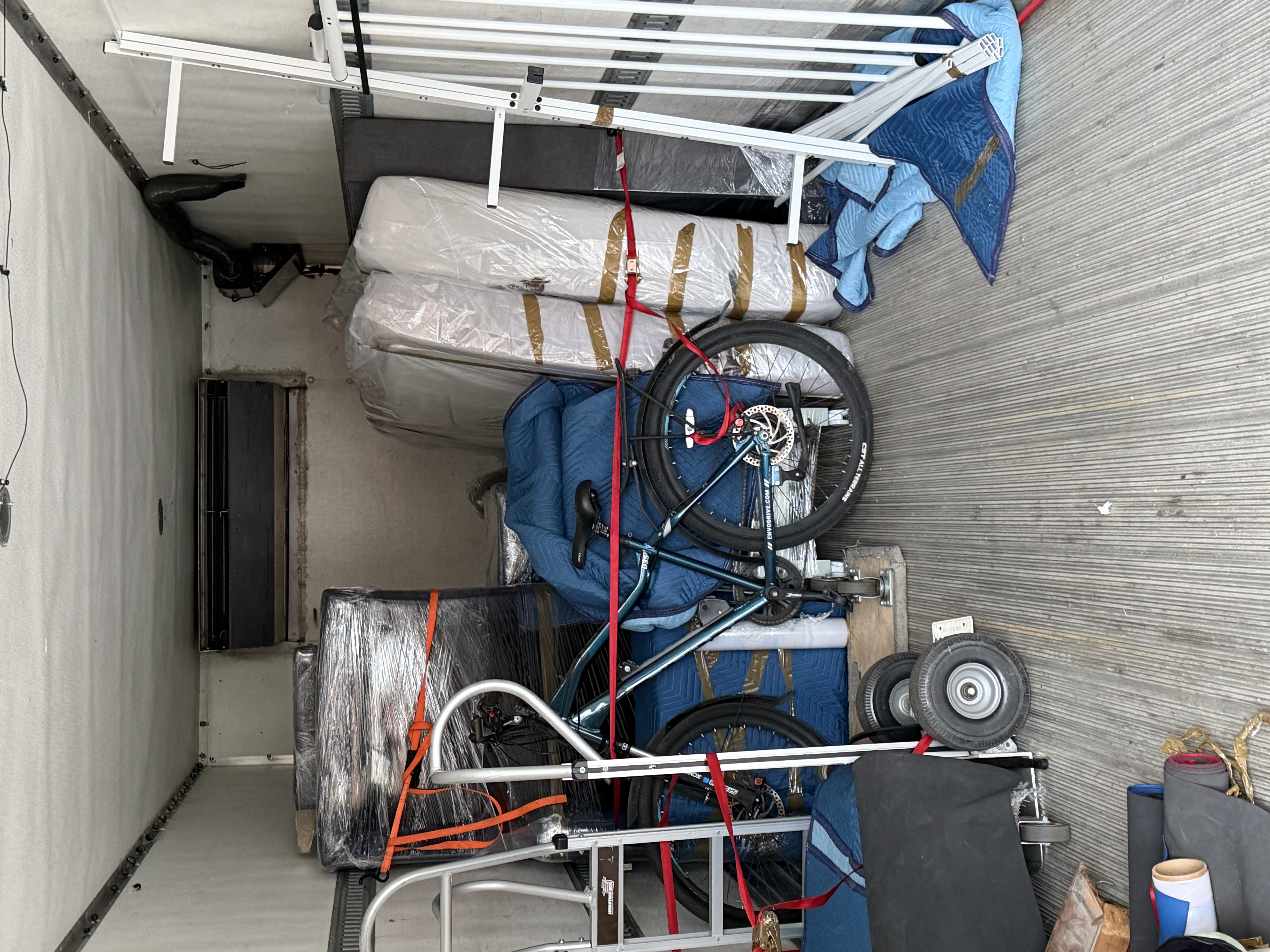 Inside the truck — mattresses, bike and furniture secured with straps