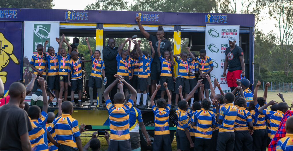 KRDA young rugby players celebrating with medals on stage