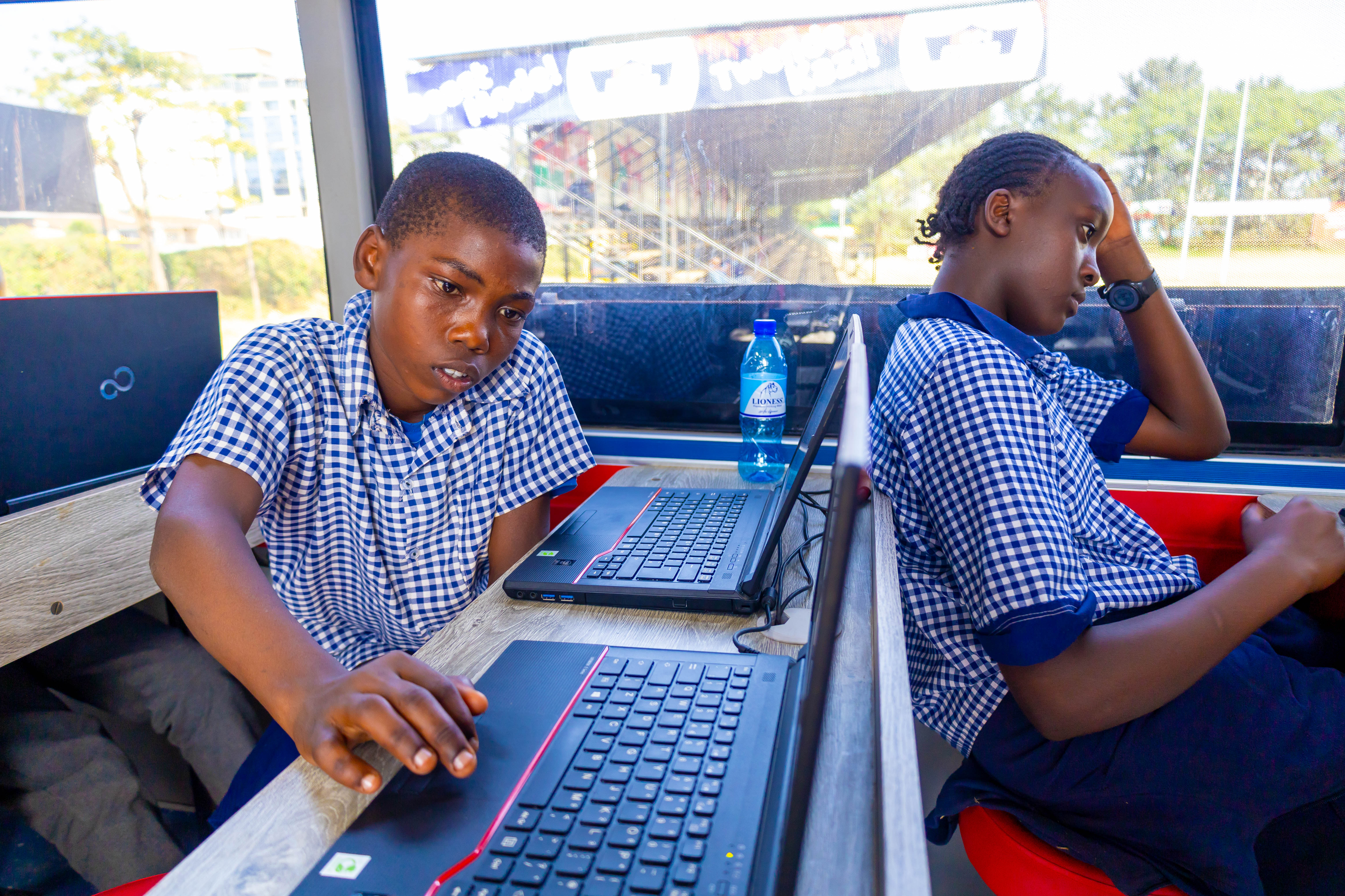 Students learning on laptops inside the Digi AI Bus
