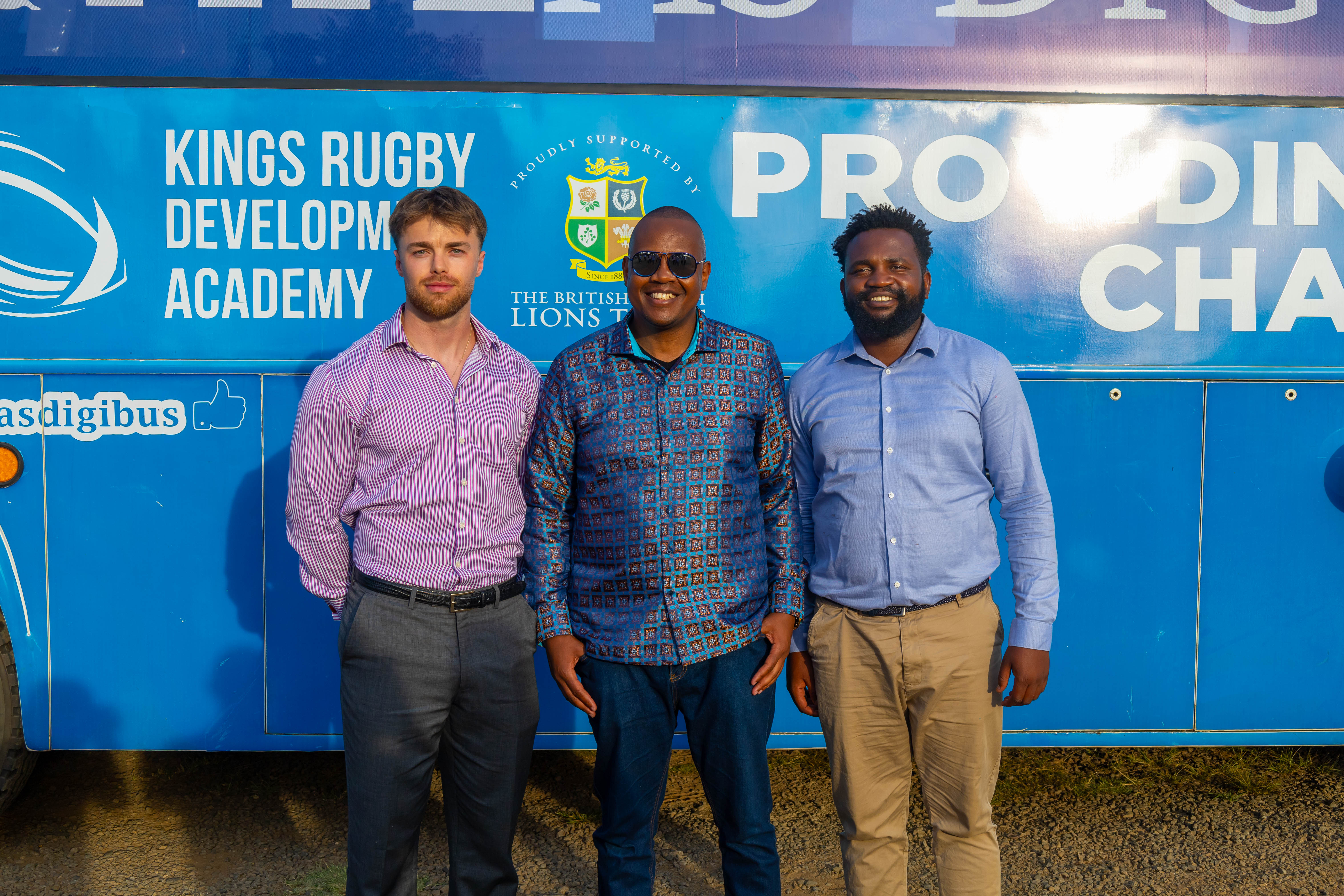 Three partners posing in front of the Digi AI Bus
