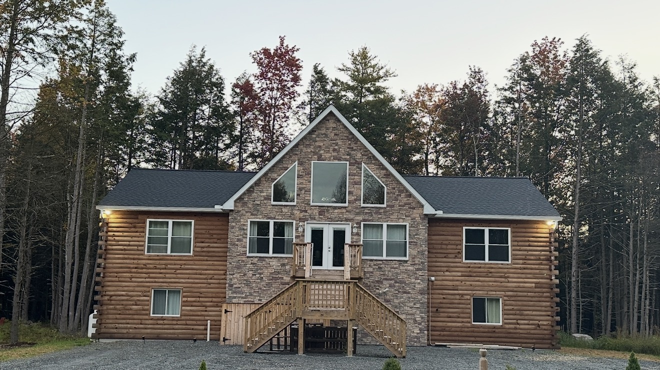 Large log home with stone gable and grand entry stair