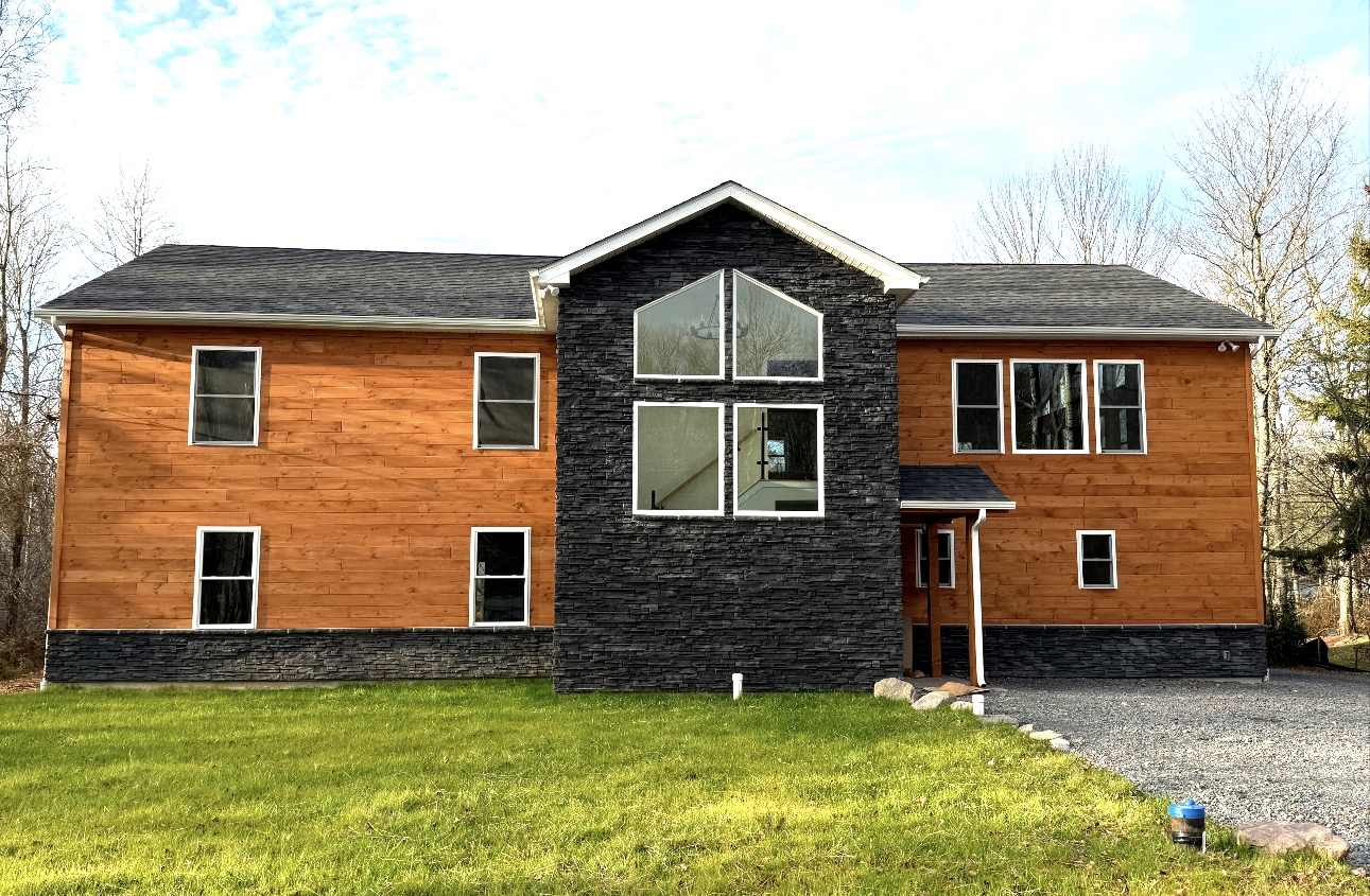 Cedar-sided home with black stone center gable
