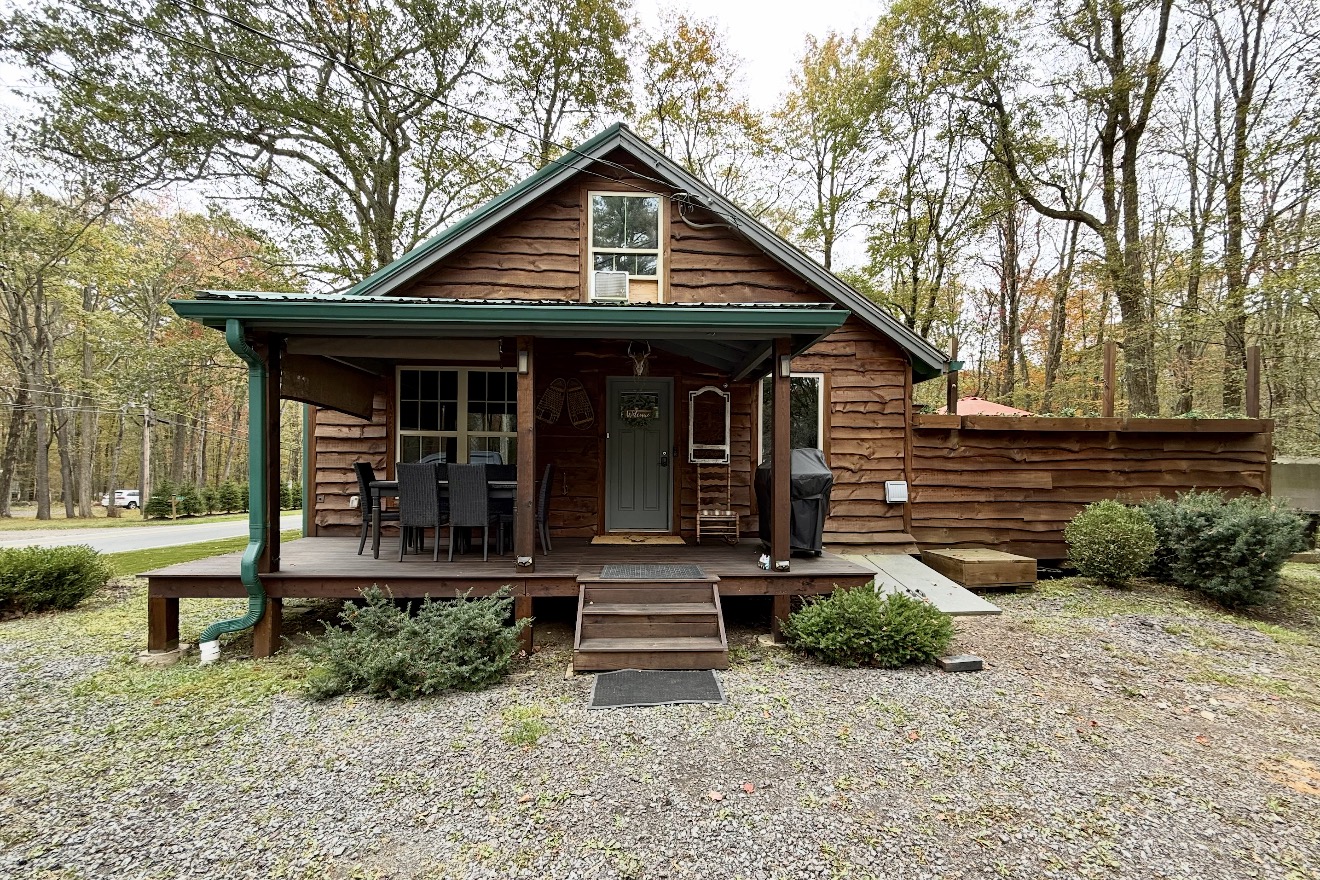 Wood-sided cabin with green metal roof and covered porch