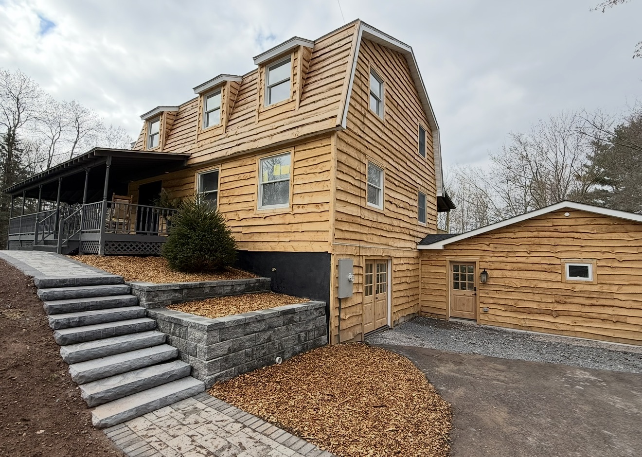 Gambrel barn-style home with stone entry steps