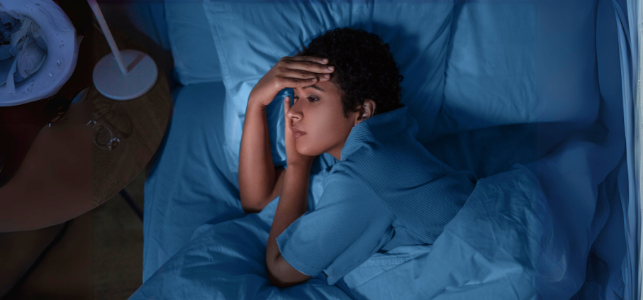 Person lying awake in bed at night