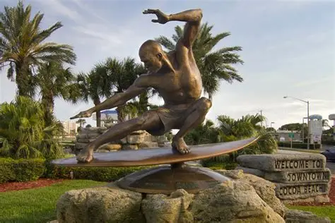 Bronze statue of surfer Kelly Slater at the Downtown Cocoa Beach sign