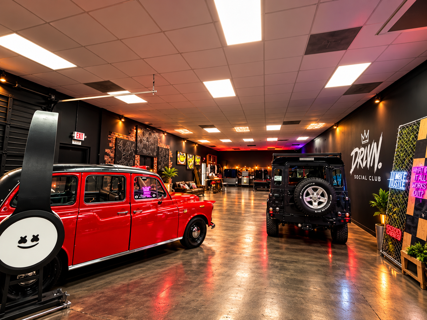 Automotive gallery with a red taxi, a black Land Rover and DRVN Social Club wall graphics