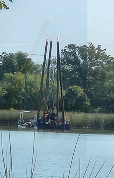 IET barge drilling platform on waterway with drill mast raised