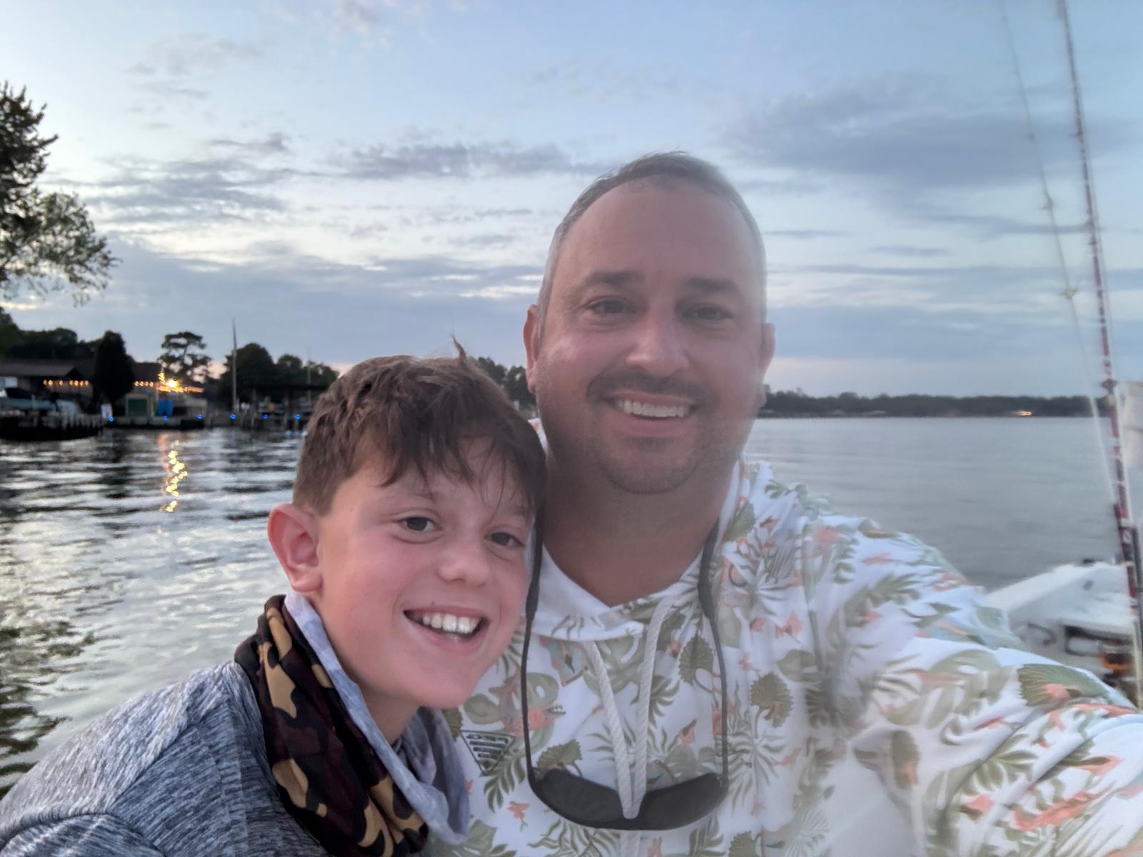 Justin Grimes with his son on a boat at twilight