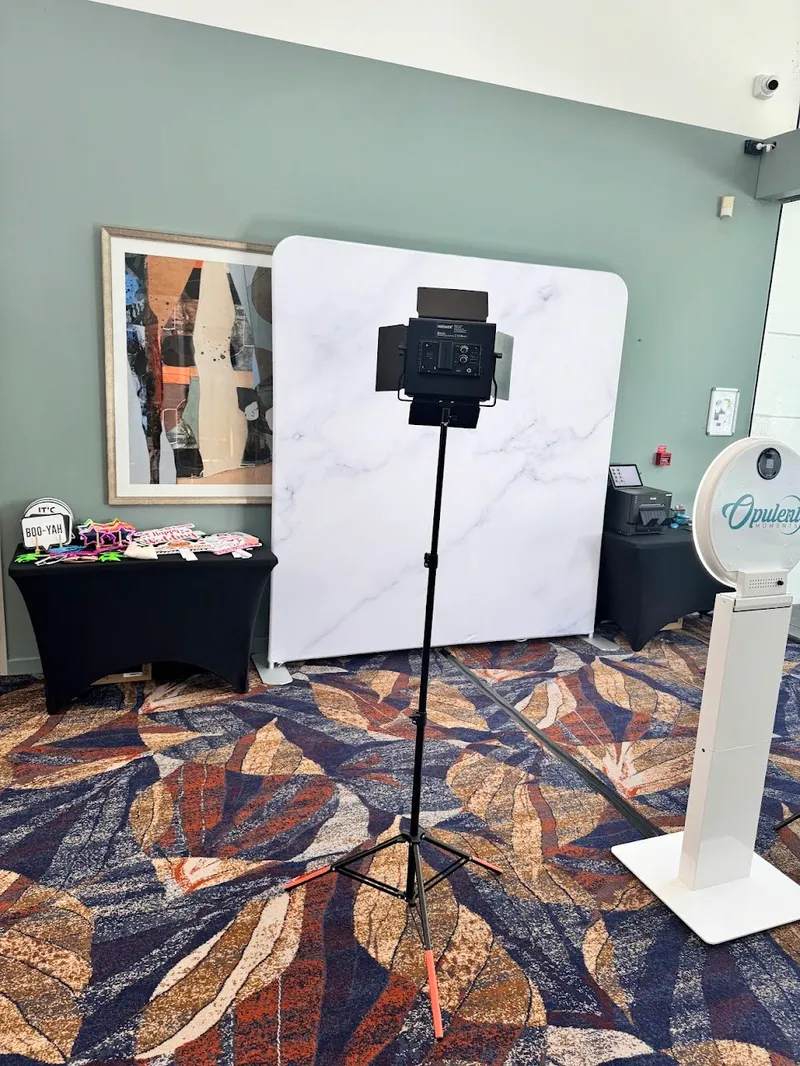 Photo booth lighting rig and marble-print backdrop set up in a function room