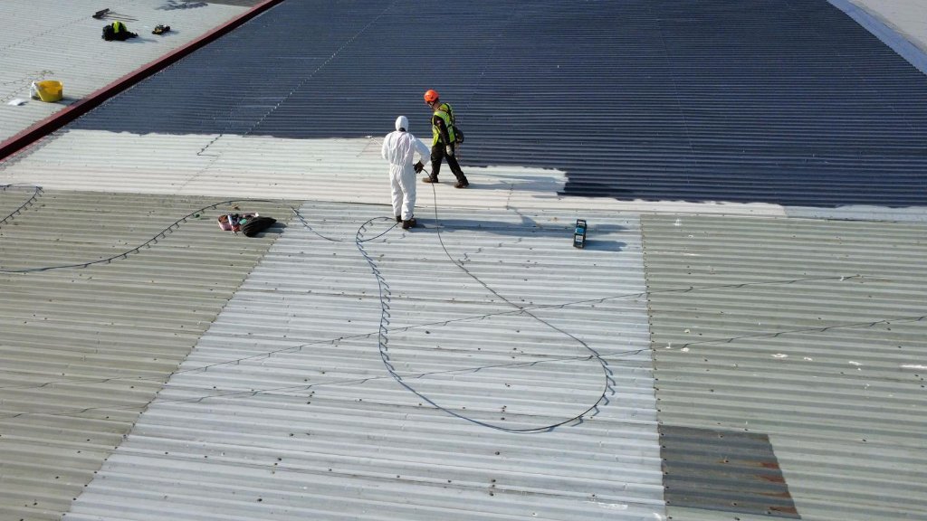 Specialist coating contractor working on a commercial roof