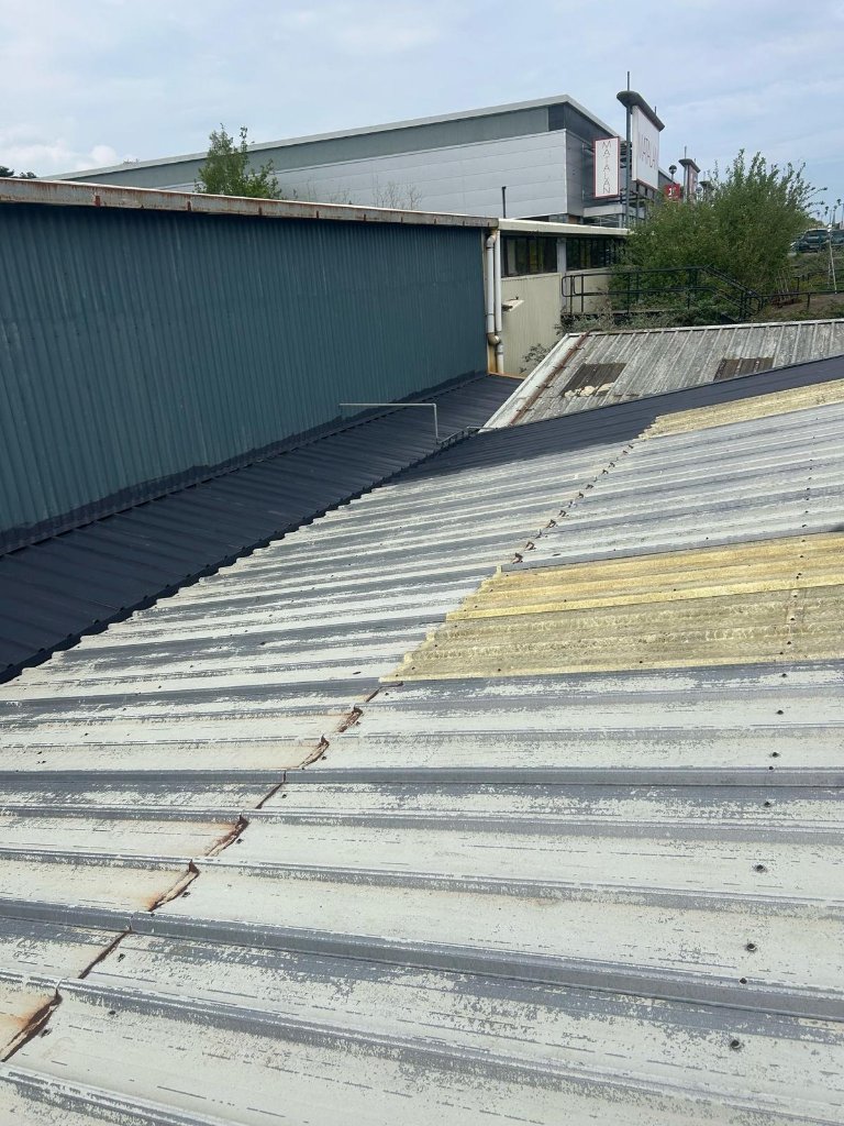 Before treatment — corroded and degraded corrugated metal roof surface showing rust and coating failure requiring TopSpray35 refurbishment