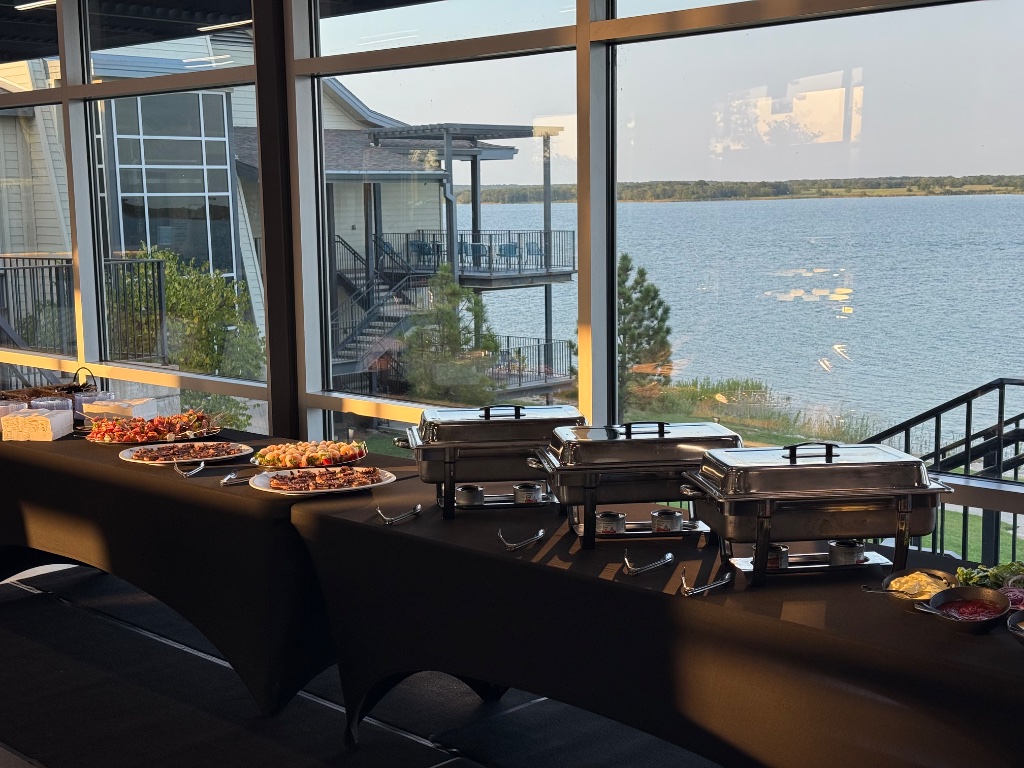 The full happy hour buffet line set against the lodge's lake-view windows