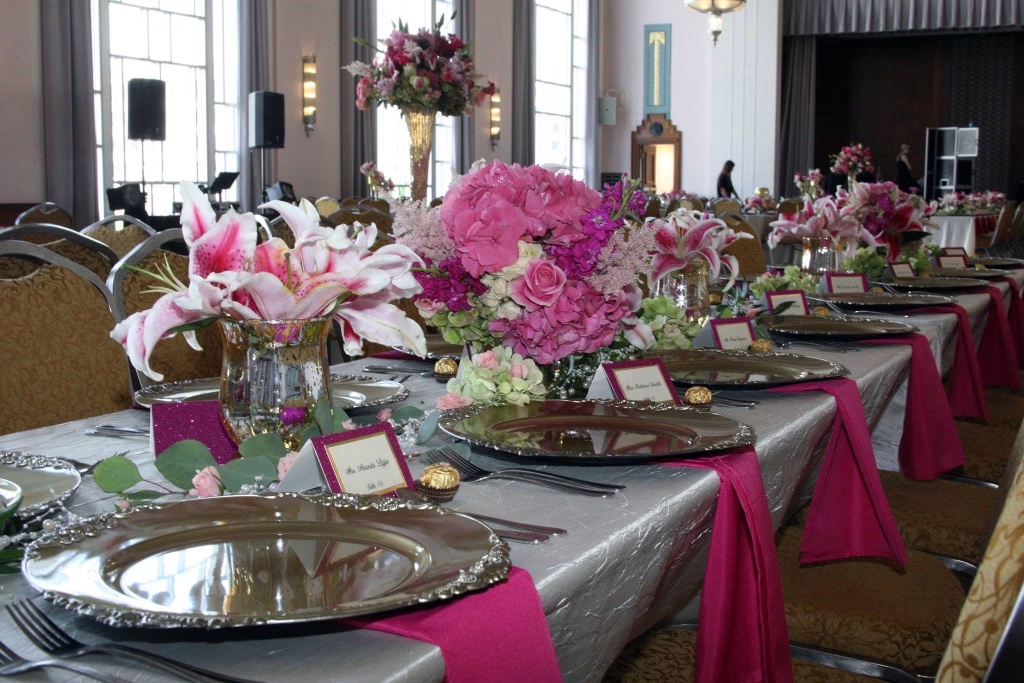 Detailed place settings with silver chargers, pink napkins, and personalized place cards