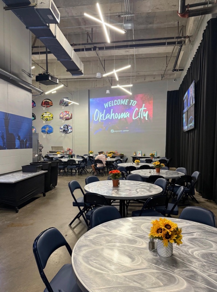 Backstage hospitality room with 'Welcome to Oklahoma City' projection