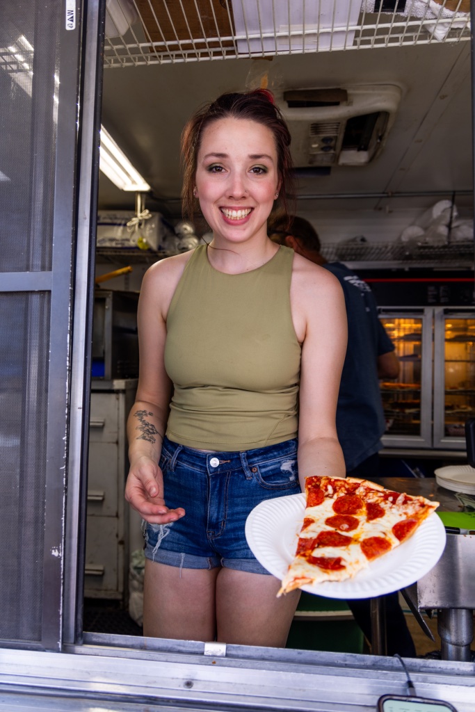 Team member handing out a food bowl at the Mac & Speed trailer window