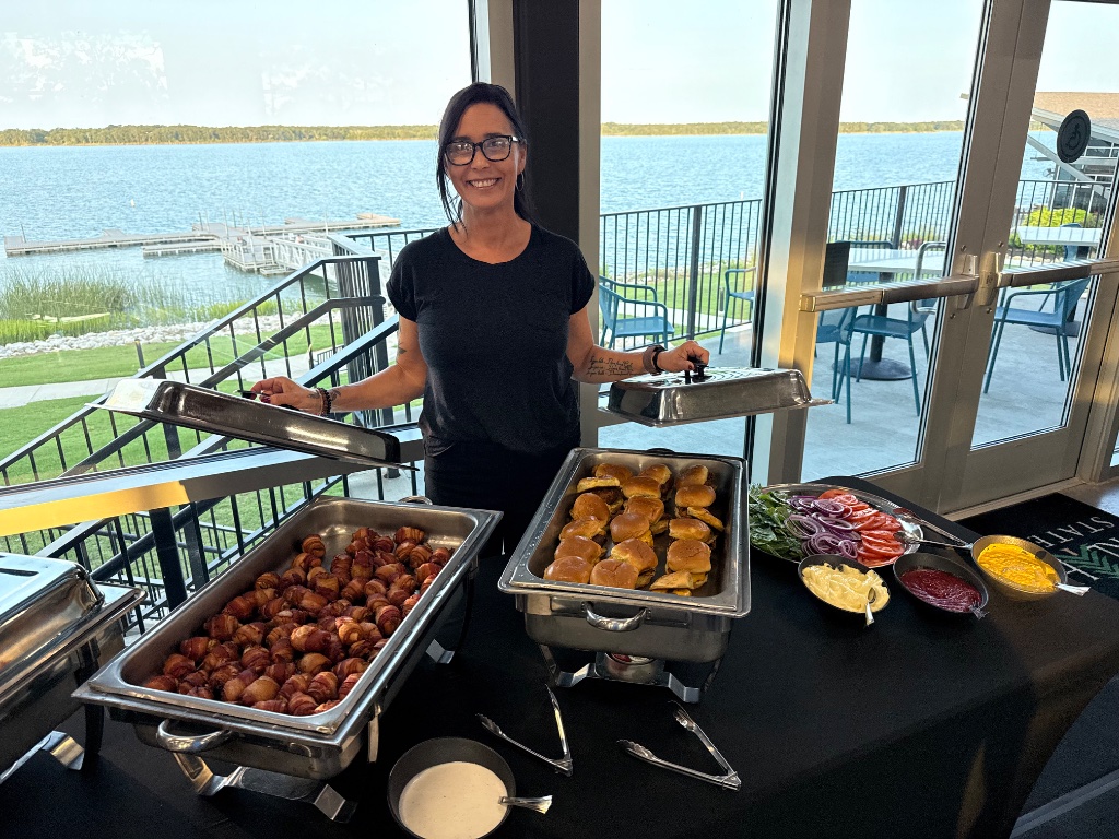 Falcone's Catering team member serving the happy hour buffet overlooking Lake Murray