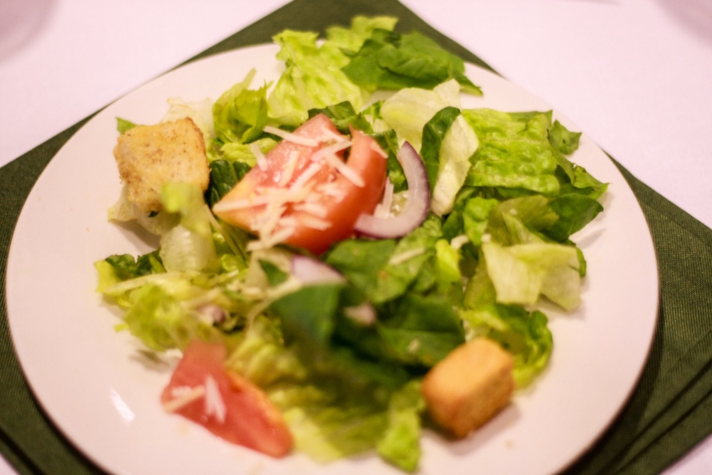 Plated garden salad with fresh greens, tomatoes, and parmesan